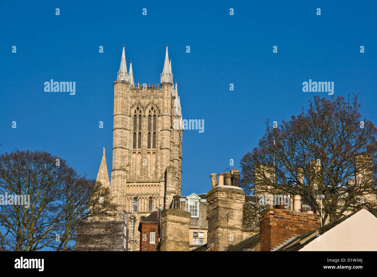 Cattedrale di Lincoln torre che si eleva al di sopra di camini e tetti Lincolnshire Inghilterra Europa Foto Stock