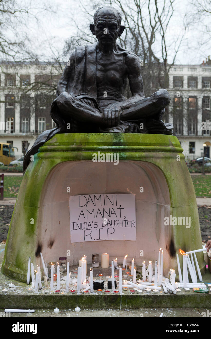 Londra, sabato 5 gennaio, 2013. Illuminazione delle candele Memorial al Mahatma Gandhi statua, Tavistsock Square Garden in London-Save le nostre sorelle. I dimostranti si sono riuniti a Tavistock Garden Square per protestare e dimostrare la loro solidarietà contro l'incidente che ha avuto luogo a Delhi, la capitale indiana, dove una donna è stata pista violentate e buttato fuori del bus in movimento a morire. NRI indiani a Londra vuole una risposta dal governo indiano per ciò che è accaduto. Le candele accese sotto la statua del Mahatma Gandhi. Foto Stock