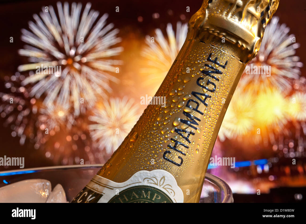 Festa con bottiglia di champagne e fuochi d'artificio, secchiello del ghiaccio con grande spettacolo di fuochi d'artificio nel cielo notturno alle spalle. Foto Stock