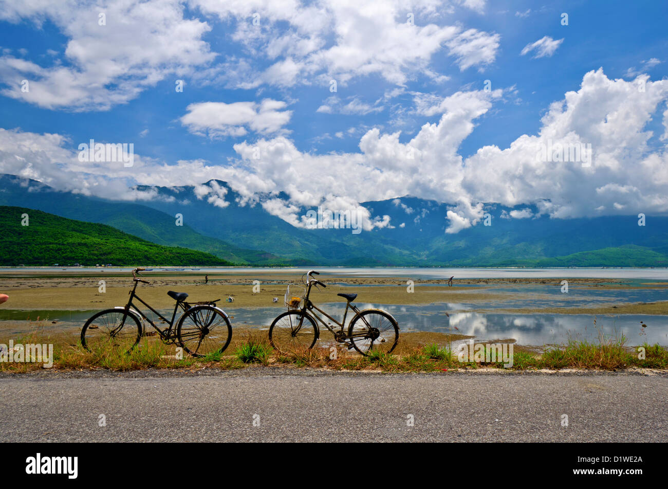 Due biciclette parcheggiata di fronte le velme e le montagne, Lang Co, Vietnam Foto Stock