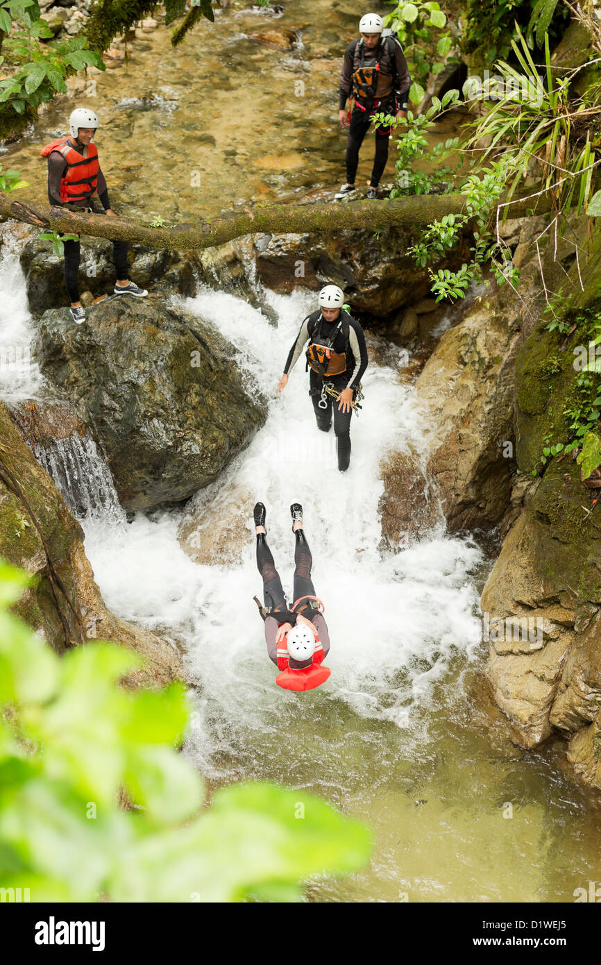 Canyoning Team di eseguire un backflip in una piccola cascata Foto Stock