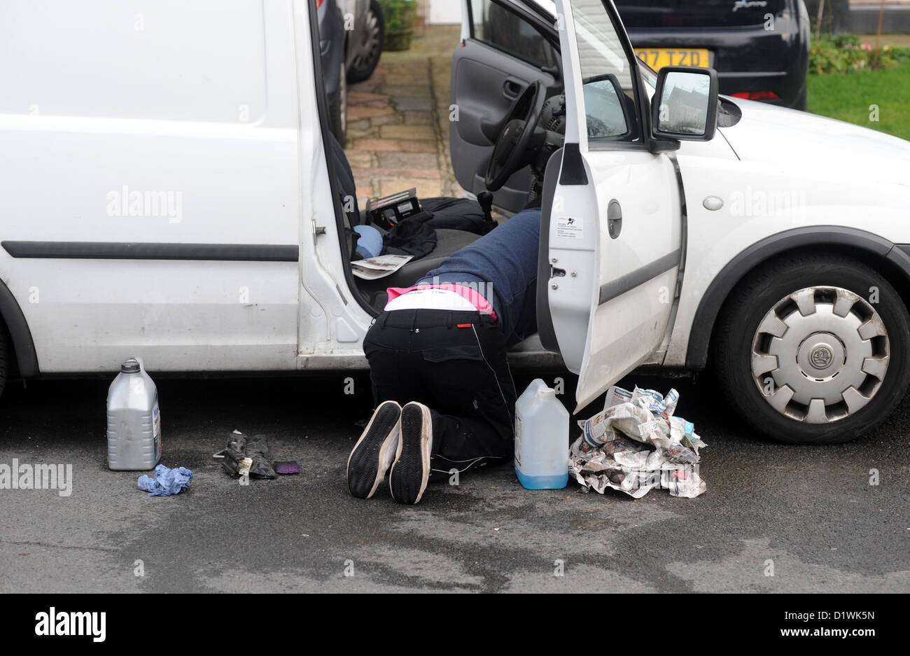 Giovane uomo di effettuare la manutenzione della sua Vauxhall van al di fuori della sua casa sulla strada Foto Stock