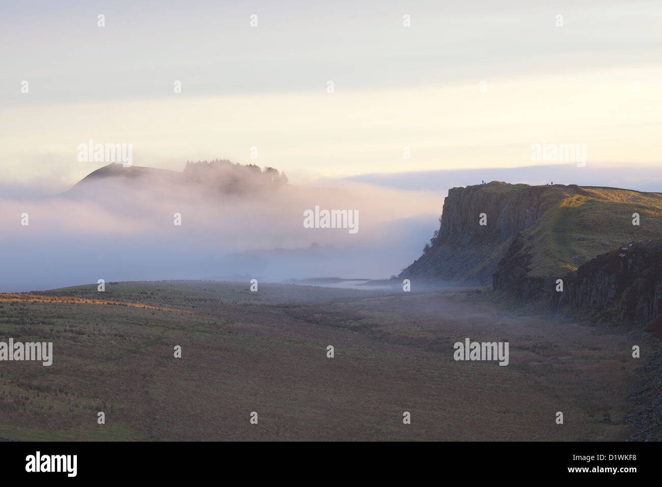 Banca a caldo e Highshield balze e roccioso del Lough nella nebbia da acciaio Rigg, il vallo di Adriano. Northumbria, (Northumberland), Inghilterra Foto Stock