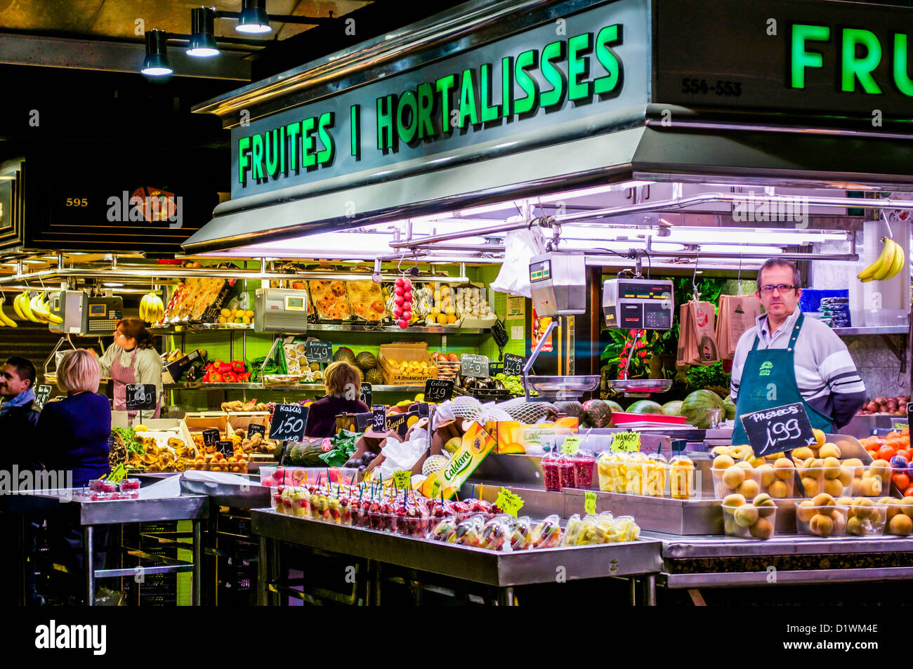 Tagliate la frutta concessionario al Mercato di Boqueria a Barcellona, Spagna. Foto Stock