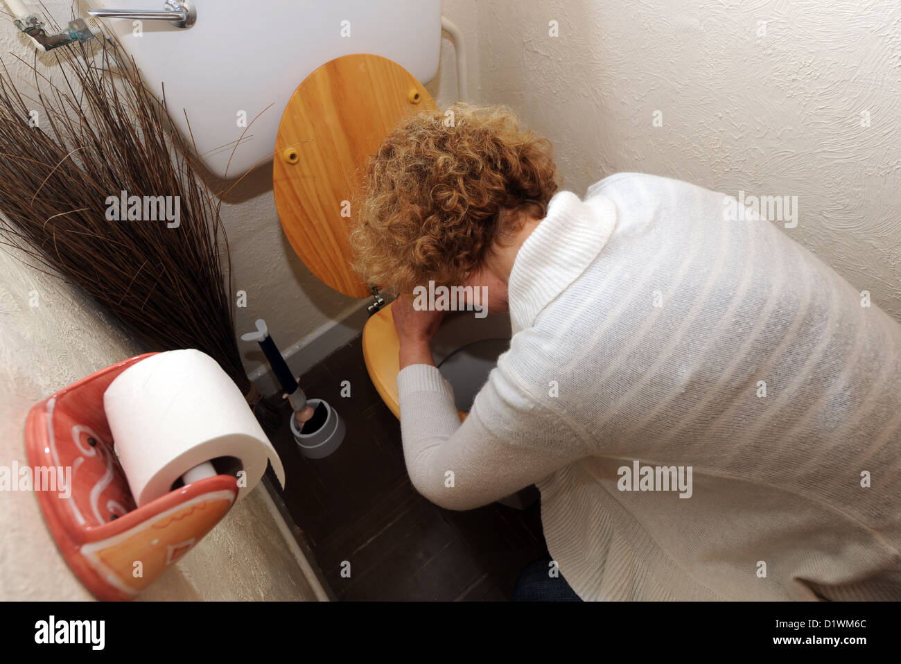 Donna che soffre di Norovirus, meglio conosciuto come il bug invernale di vomito, che è il più comune bug stomaco nel Regno Unito (posato dal modello) Foto Stock