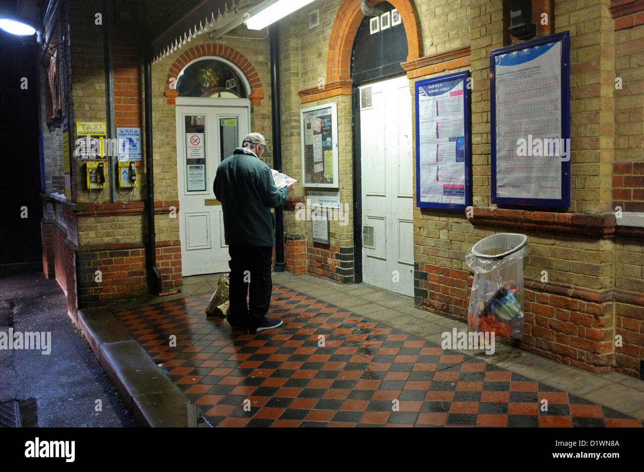 In attesa di un taxi al di fuori di una stazione ferroviaria in Hampshire, Regno Unito Foto Stock