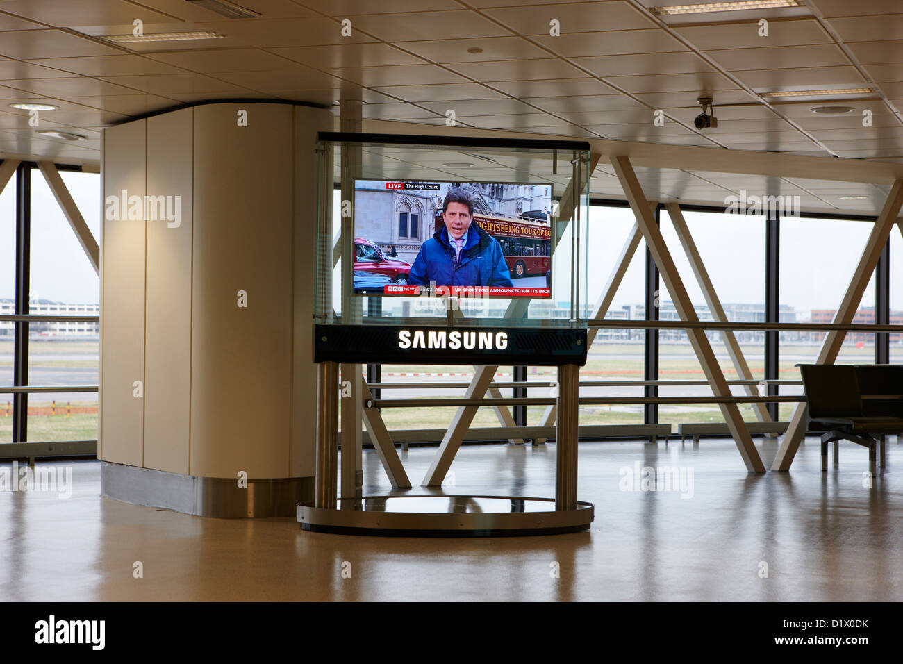 Samsung pannello di grandi dimensioni che mostra la televisione BBC news al terminal 1 terminal passeggeri la costruzione di Heathrow airport LONDON REGNO UNITO Foto Stock