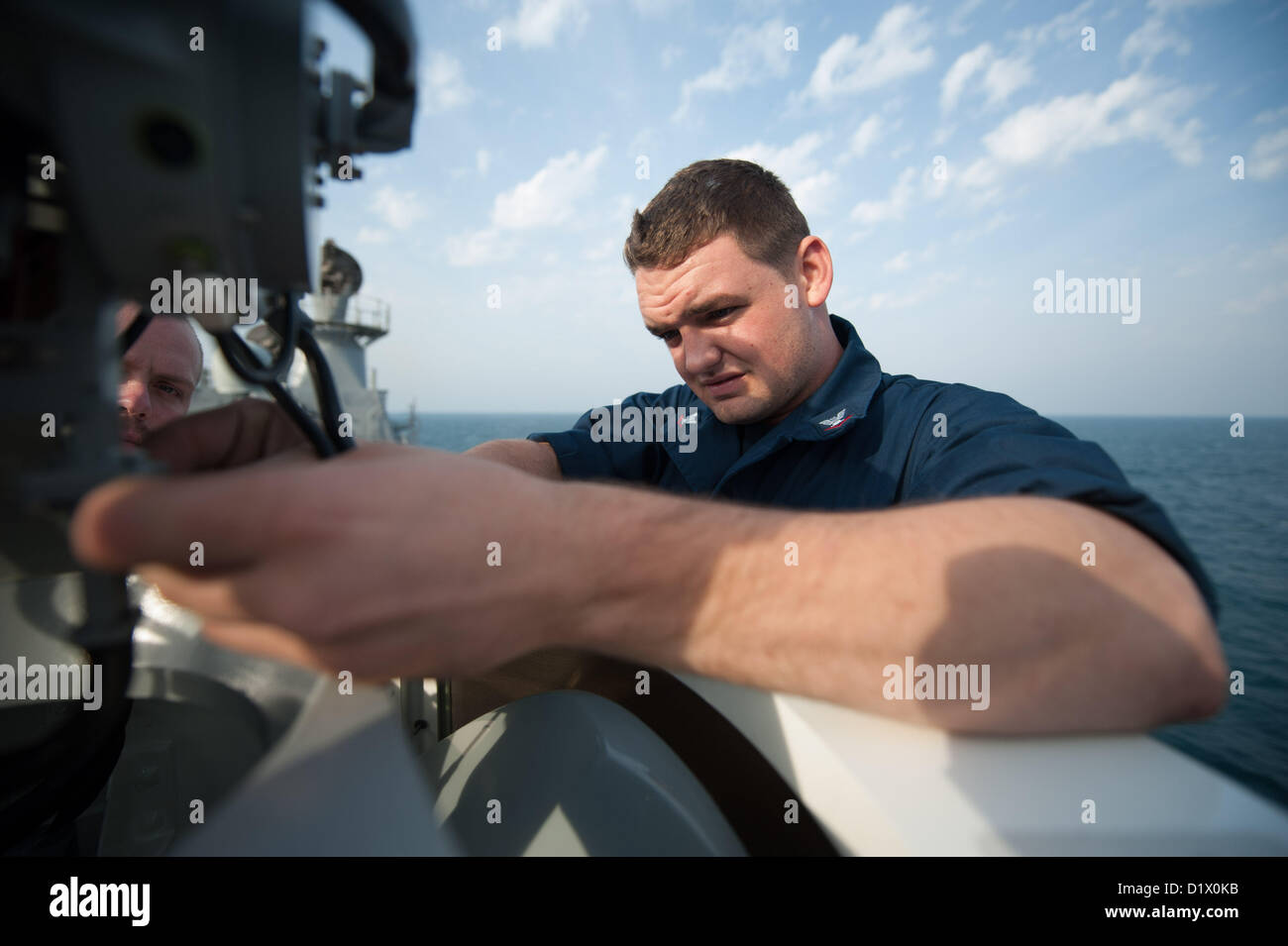 Da bombardieri Mate 3° di classe Franklin Troyer da Grand Rapids, Mich, esegue le operazioni di manutenzione sulla cima di un vicino-in sistema di armi a bordo della Ticonderoga-class guidato-missili cruiser USS Mobile Bay (CG 53). Mobile Bay è distribuito con il John C. Stennis Strike gruppo per gli Stati Uniti Quinta Flotta area di responsabilità condurre le operazioni di sicurezza marittima, teatro la cooperazione in materia di sicurezza gli sforzi e le missioni di sostegno per l'Operazione Enduring Freedom.Jan 7, 2013 (U.S. Foto di Marina di Massa lo specialista di comunicazione 2a classe Armando Gonzales/rilasciato) Foto Stock