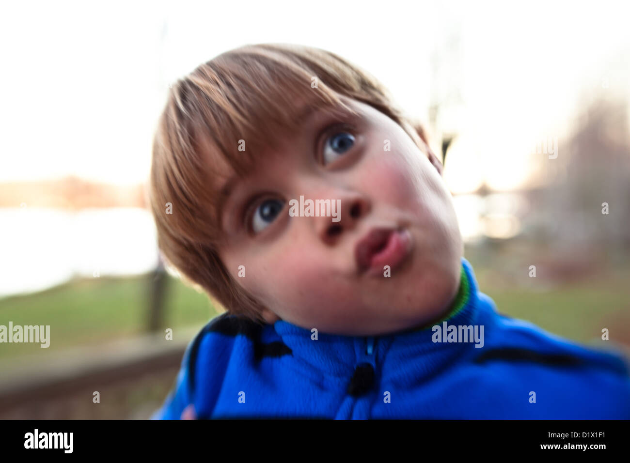 Little Boy facendo facce ed essendo stupido al di fuori della sua casa Foto Stock