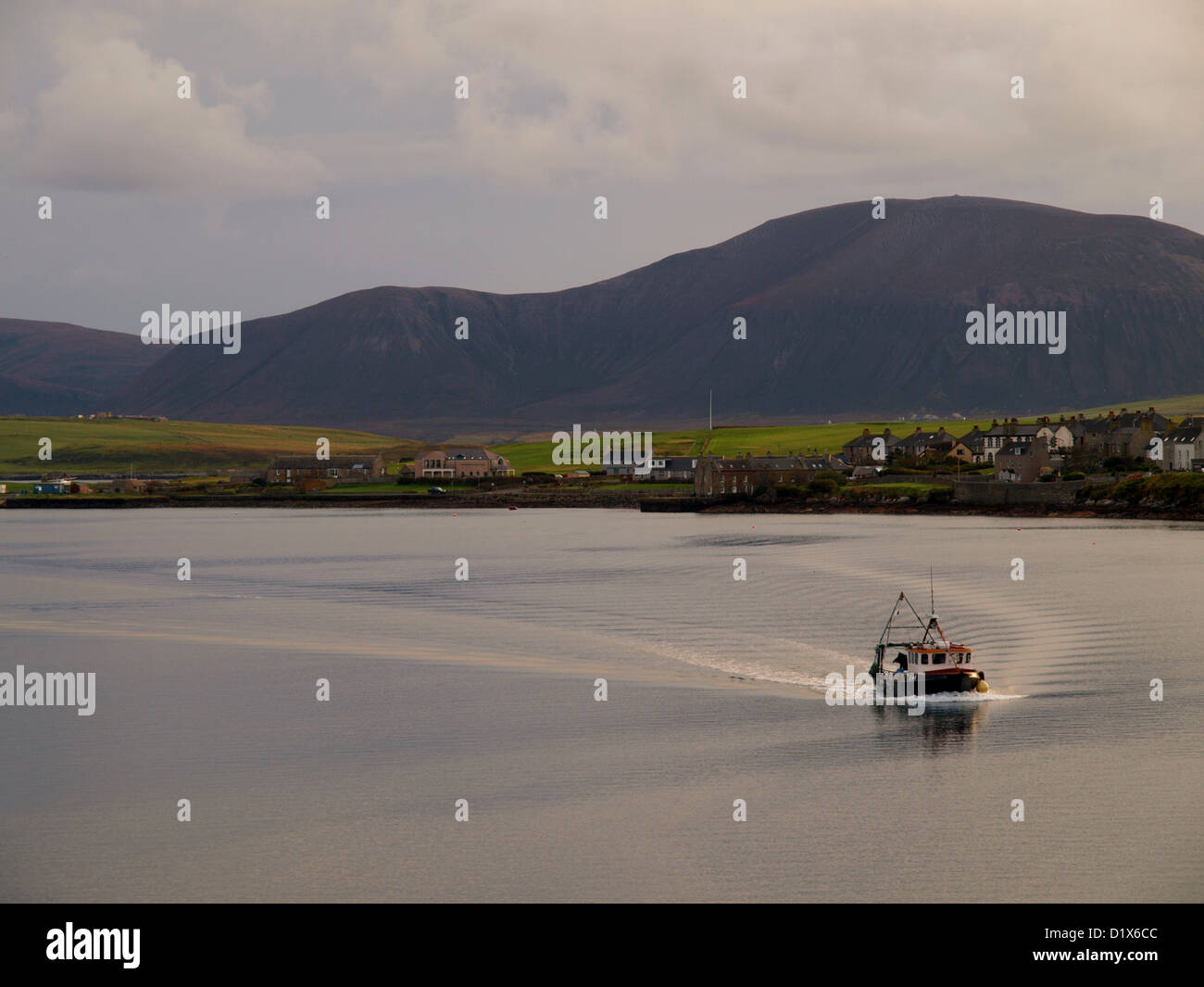 Una barca da pesca ritorna all'Orkney città di Stromness in Scozia, isole del nord Foto Stock