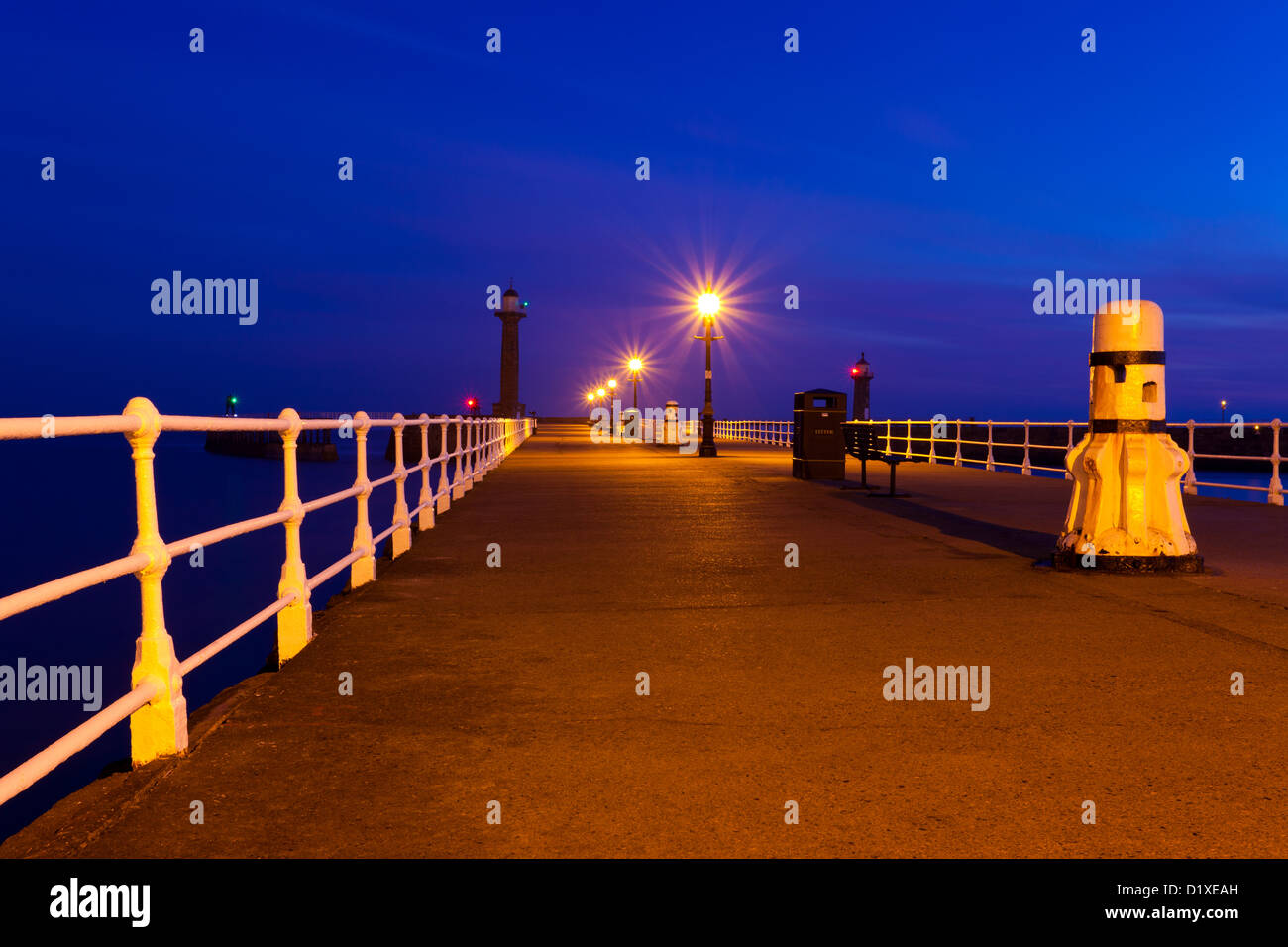 Il molo a Whitby North Yorkshire preso poco prima del sorgere del sole con le lampade colata le loro candele Foto Stock