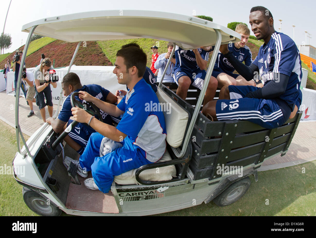I giocatori di calcio da FC Schalke 04 sono indietro di guida nel loro albergo in un golf buggie oltre il campo di calcio a Doha, in Qatar nel gennaio del 07.01.2013. Schalke rimarrà in Qatar-winter training camp fino al gennaio 11.2013. Foto: Peter Kneffel/dpa Foto Stock