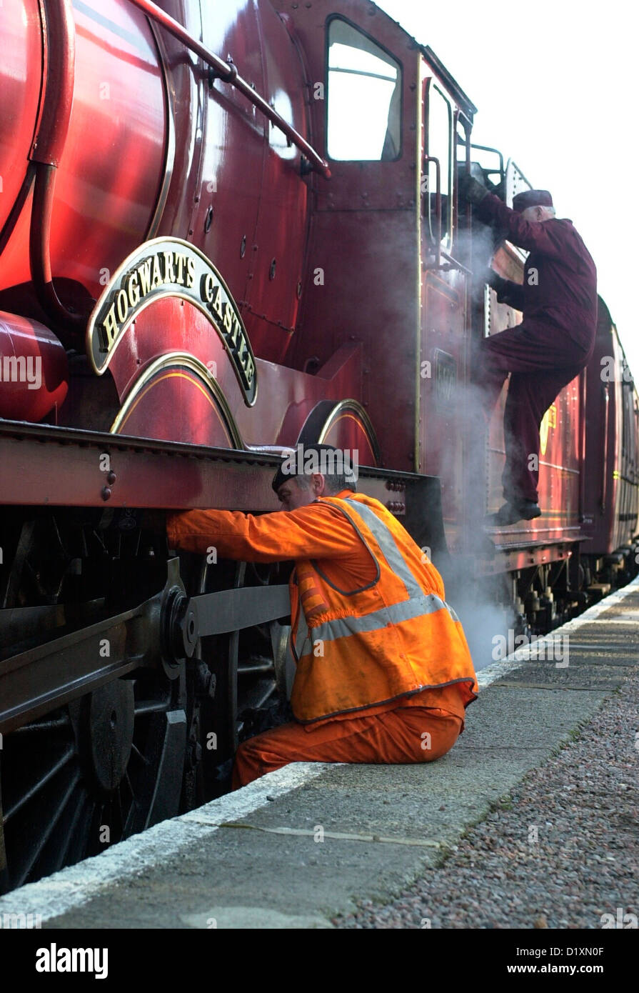 La scuola di Hogwarts Express treno da Harry Potter film in treno  Glenfinnan con il macchinista lubrificando le ruote Foto stock - Alamy