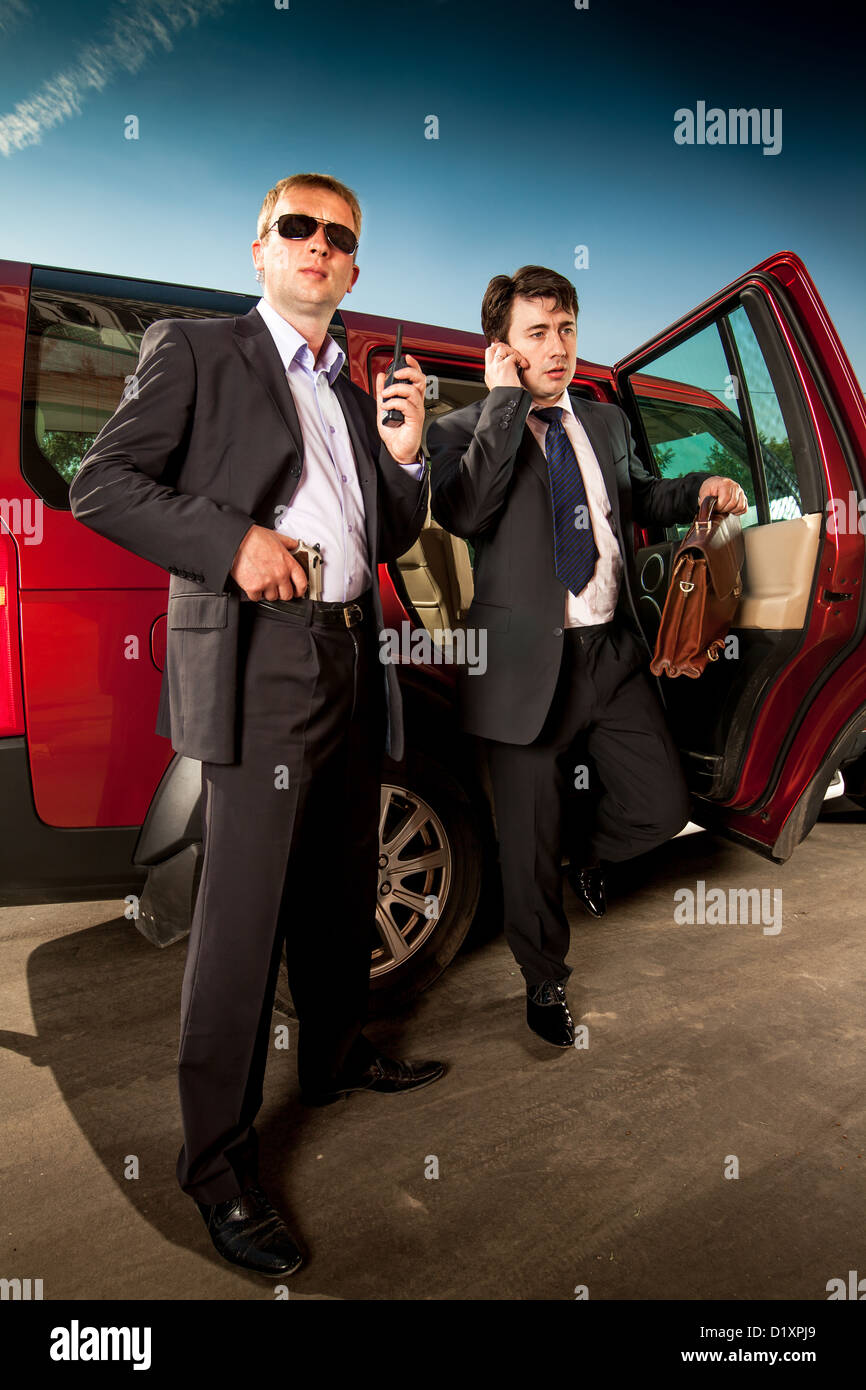 La guardia del corpo e il suo boss lasciare l' auto Foto Stock