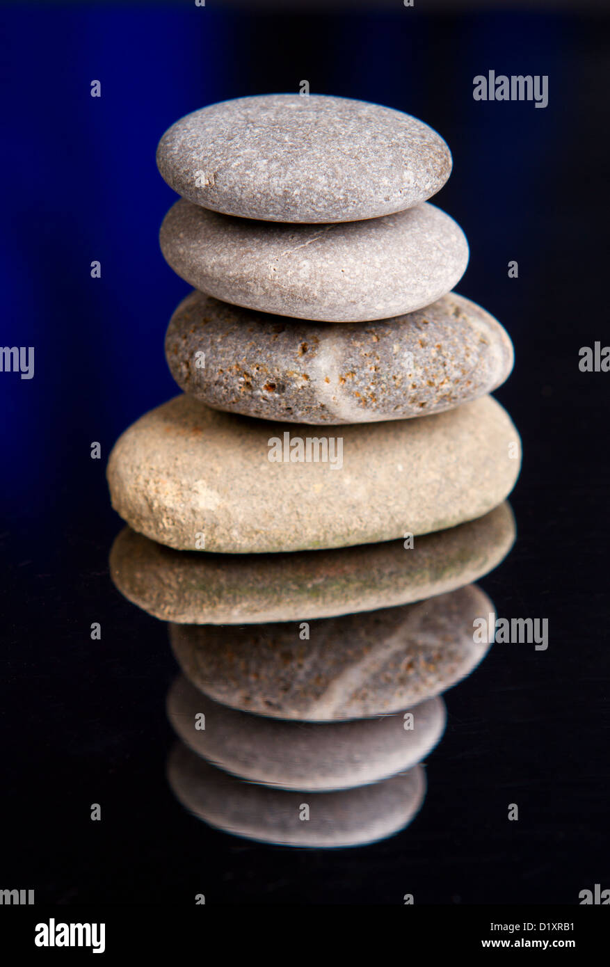 Pila di pietre equilibrata con ombre scure Foto Stock