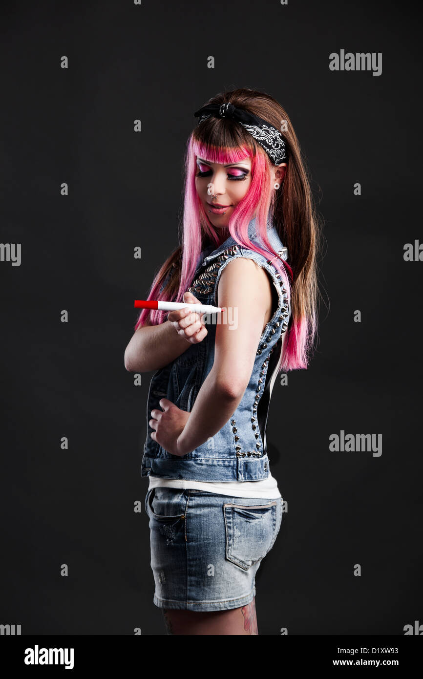 Ritratto di una giovane ragazza punk con un bel taglio di capelli in rosa di disegno di un tatuaggio Foto Stock
