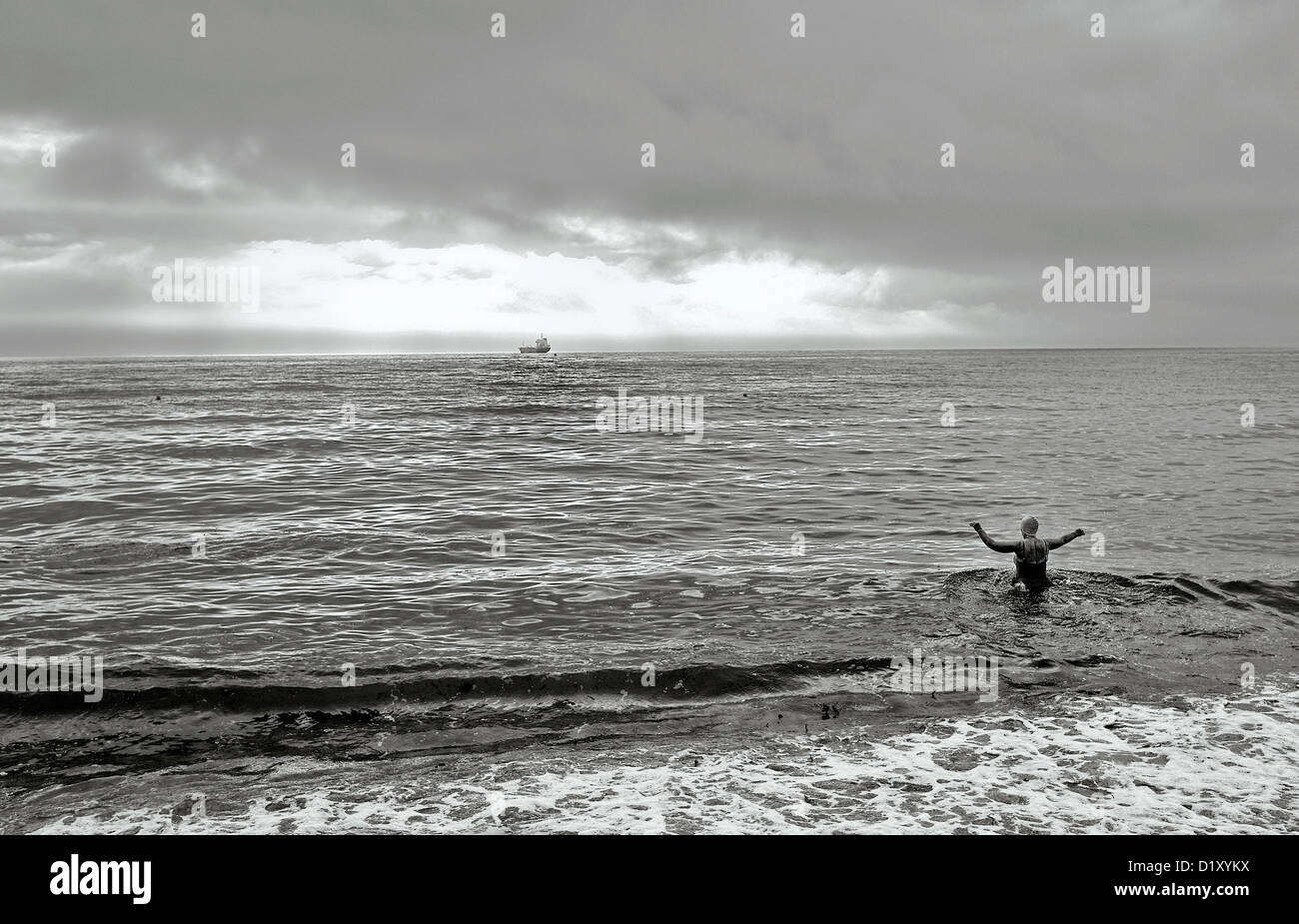 Una mezza età nuotatore femmina braves acque fredde di Falmouth, Cornwall, Regno Unito Foto Stock