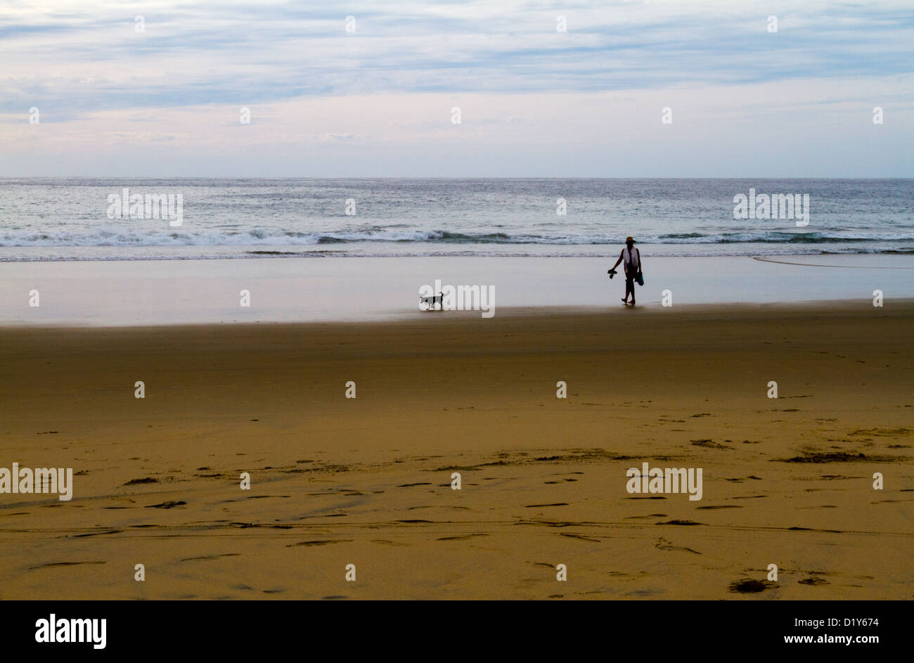 Una donna cammina il suo cane su di una spiaggia appartata vicino a Todos Santos, Baja, Messico Foto Stock