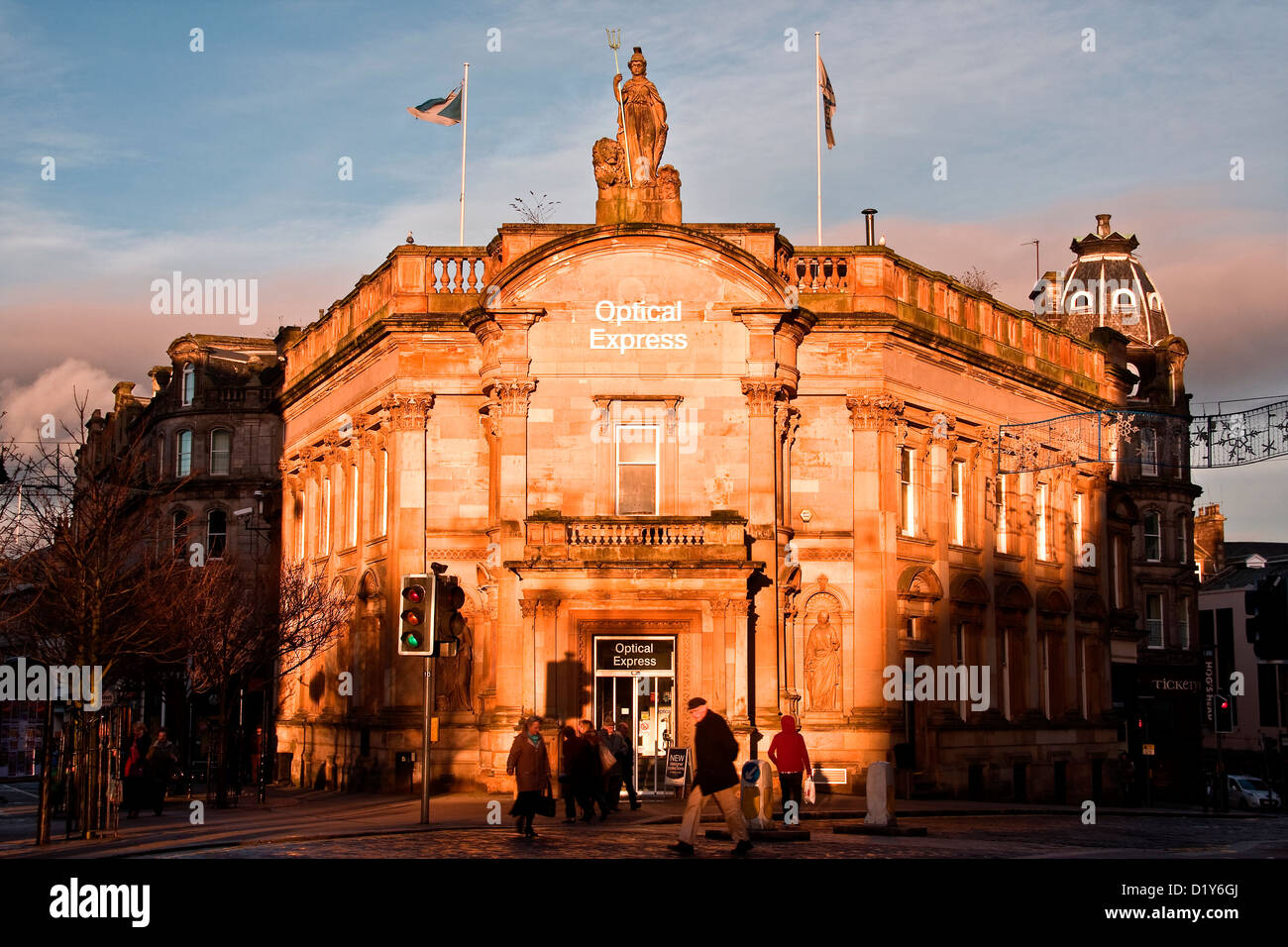 Basso livello di inverno che riflette la luce solare e la colata lunghe ombre scure in ottica Express edificio retail a Dundee, Regno Unito Foto Stock