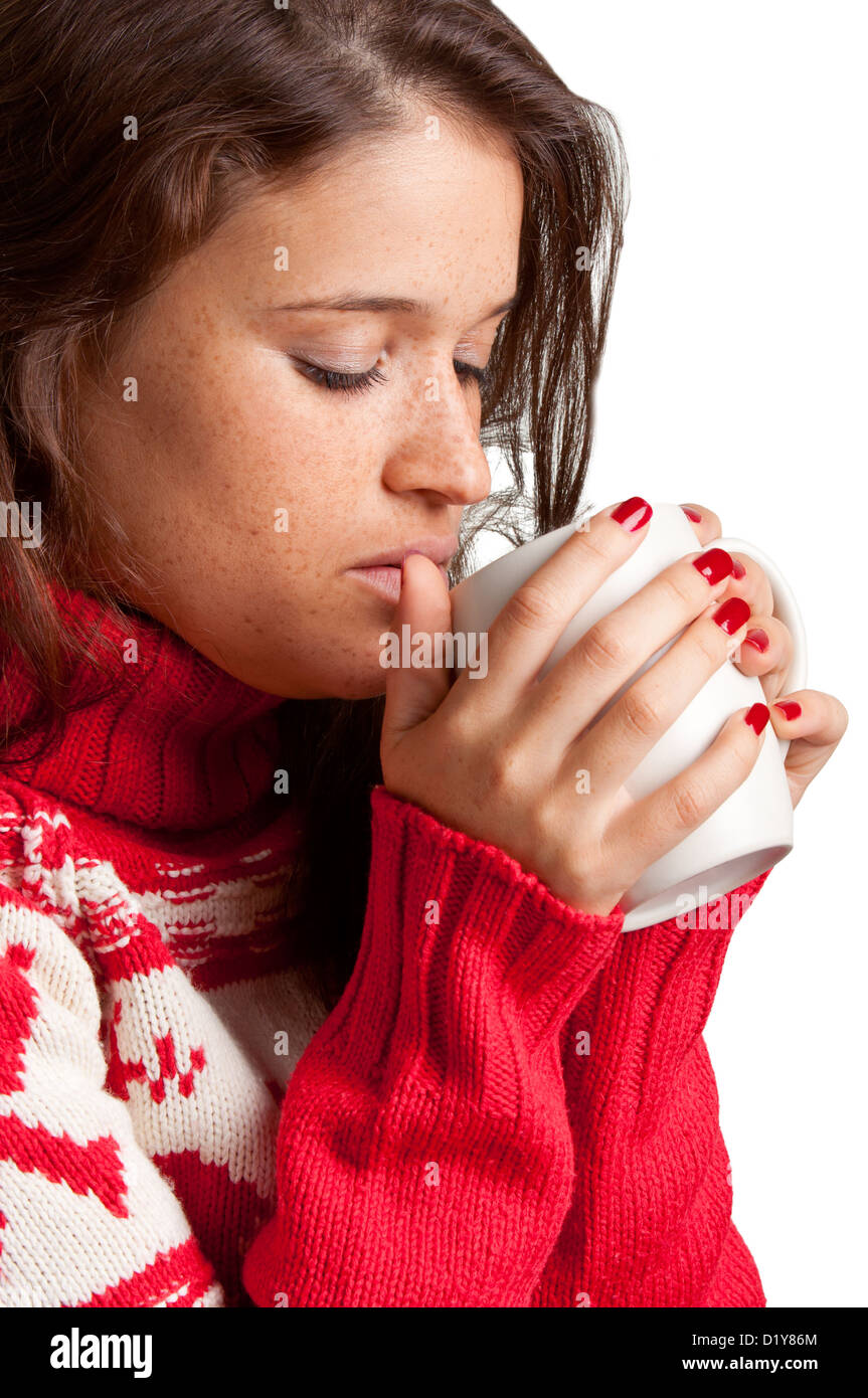 Giovane donna di bere una bevanda calda da un bianco mug, isolato in uno sfondo bianco Foto Stock