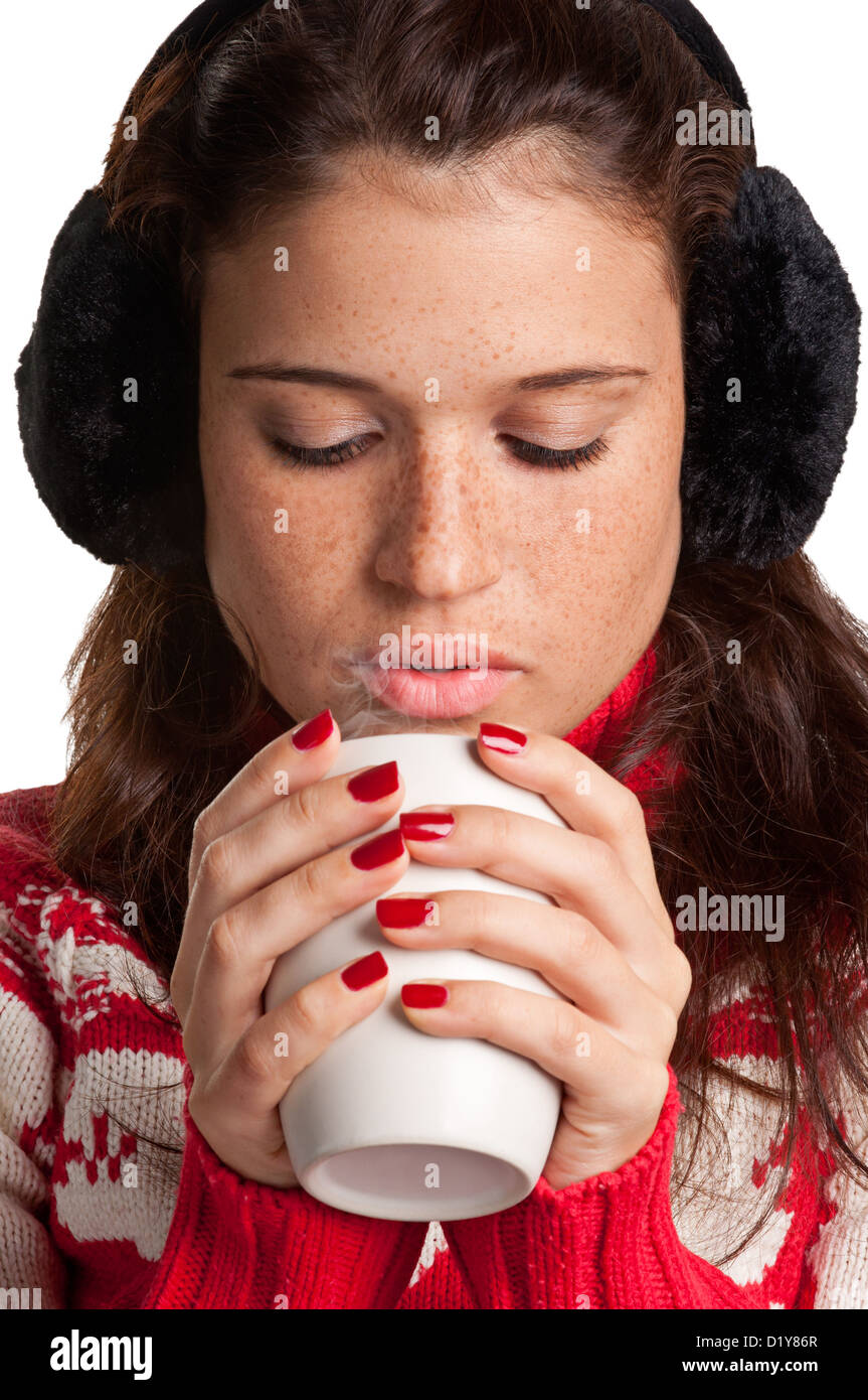 Giovane donna di bere una bevanda calda da un bianco mug, isolato in uno sfondo bianco Foto Stock