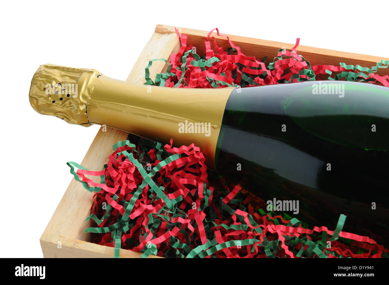 Primo piano di una bottiglia di champagne in un legno nella cassa di spedizione con shredded carta di riempimento in vacanza di Natale a colori. Foto Stock