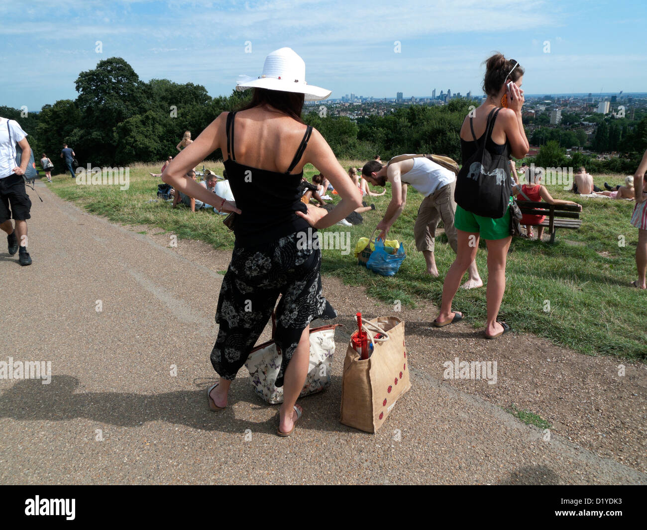 Le persone sulla Collina del Parlamento di imballare i loro sacchi dopo aver trascorso una giornata di caldo in agosto Hampstead Heath in North London NW3 Inghilterra Foto Stock