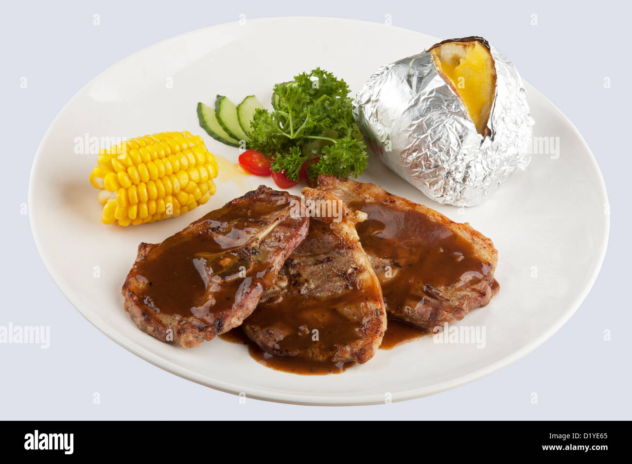 Osso in agnello con salsa gravy e il mais e patate al forno con tracciato di ritaglio Foto Stock