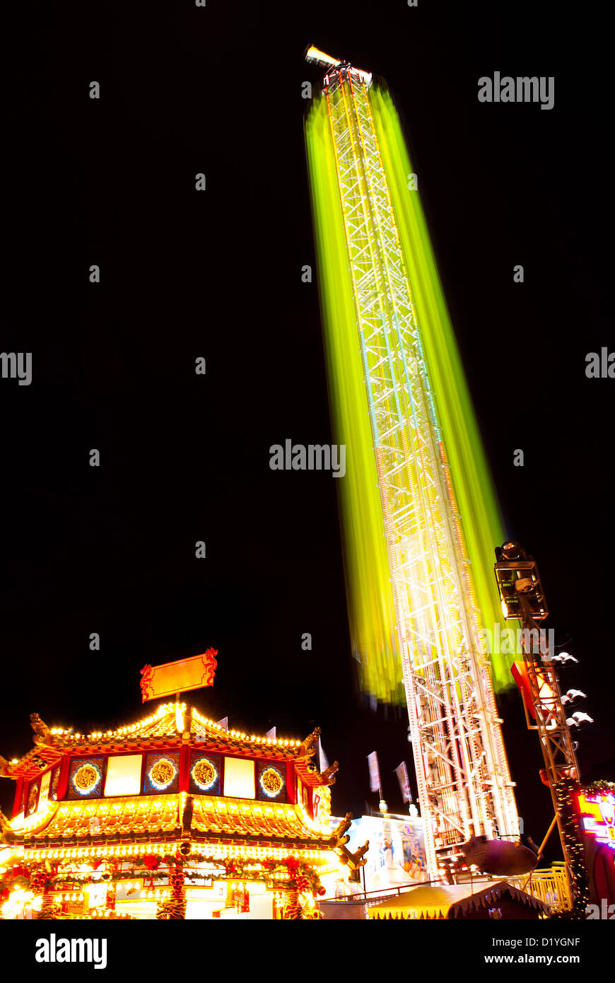 Una lunga esposizione di foto del parco dei divertimenti di giostre e ruote di notte Foto Stock