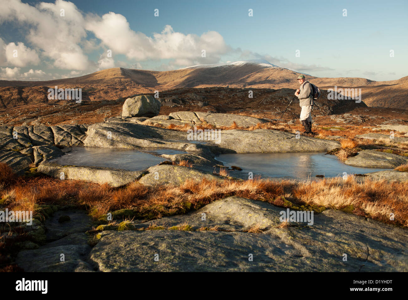 Galloway colline, aspra e selvaggia inverno verticale walker su Craiglee guardando attraverso il roccioso, granito, per una neve sormontato Merrick Foto Stock