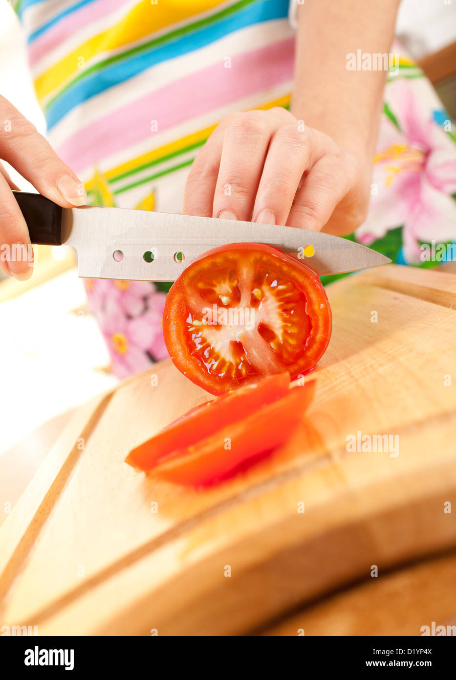 Donna con le mani in mano il taglio di pomodoro, un coltello affilato. Foto Stock