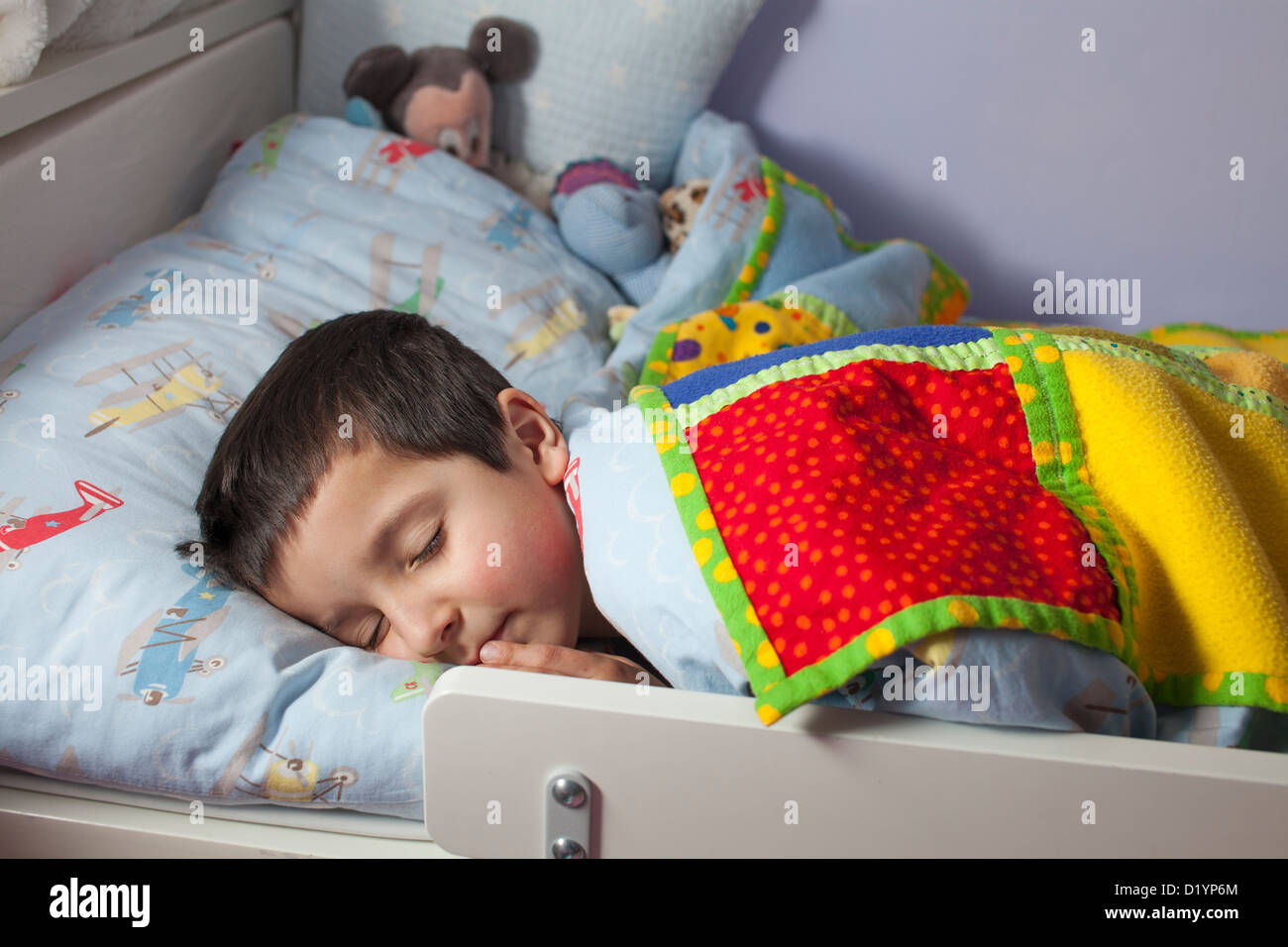 Ragazzo giovane addormentato nel letto. Foto Stock