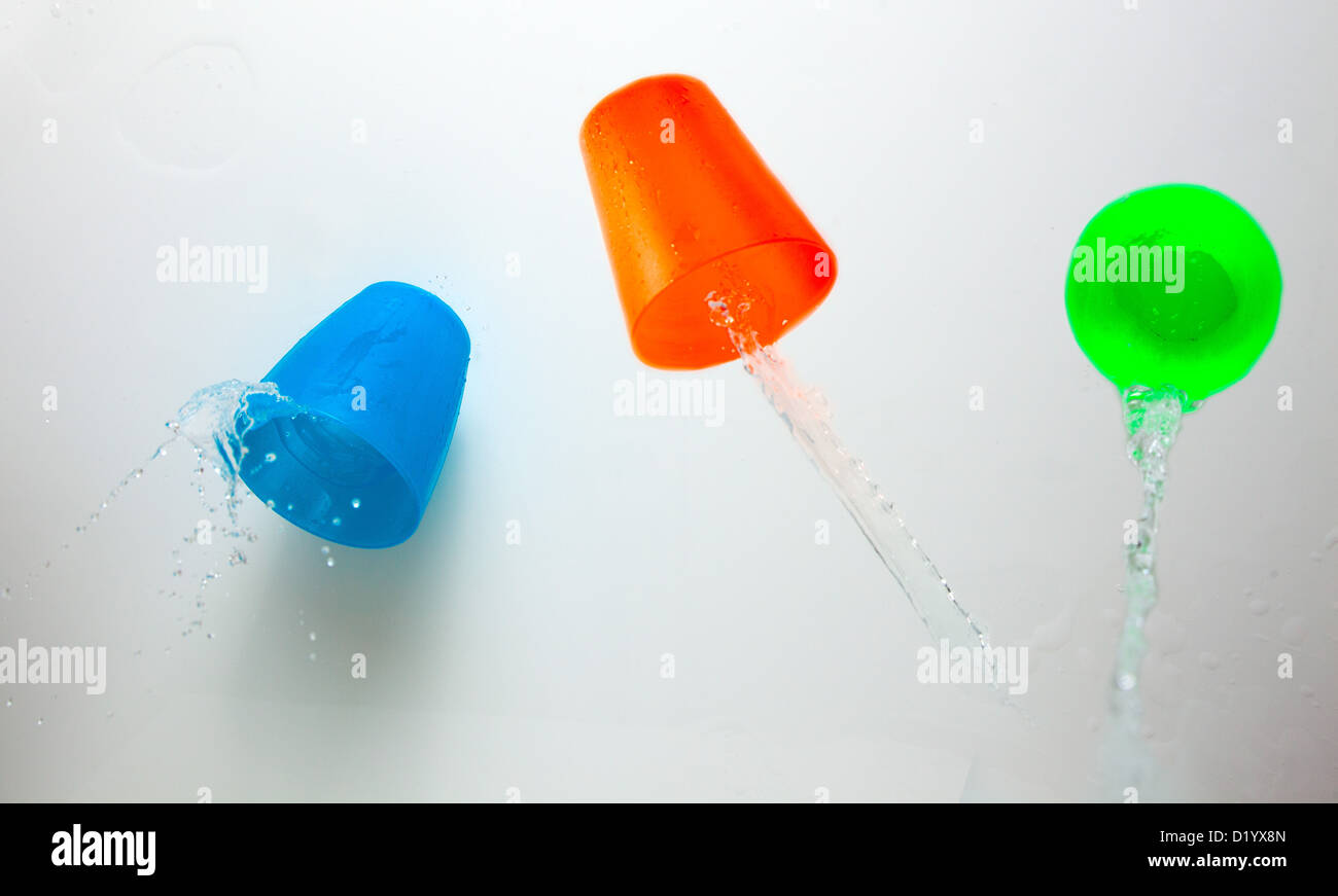 Tre bambini in plastica multicolore tazze con schizzi Foto Stock