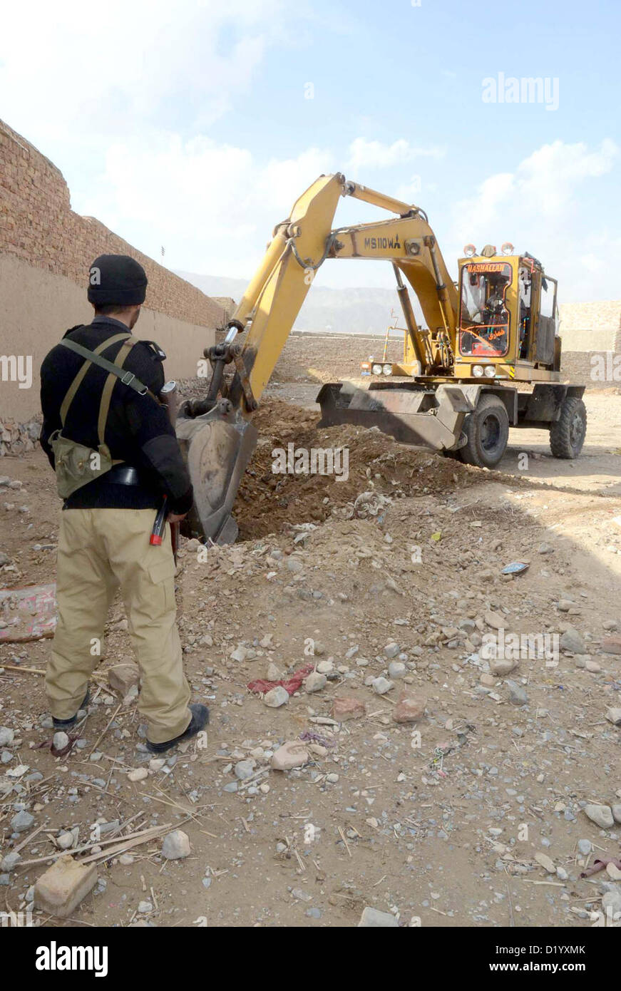 Macchinari pesanti di terra di scavo per trovare arma durante un raid sulla delimitazione delle arrestati accusati, a Quetta bypass su Mercoledì, Gennaio 09, 2013.Le armi sepolto nel cantiere di una casa e sono stati da utilizzare nel settaria attività terroristiche, dichiarato dal accusato. Foto Stock