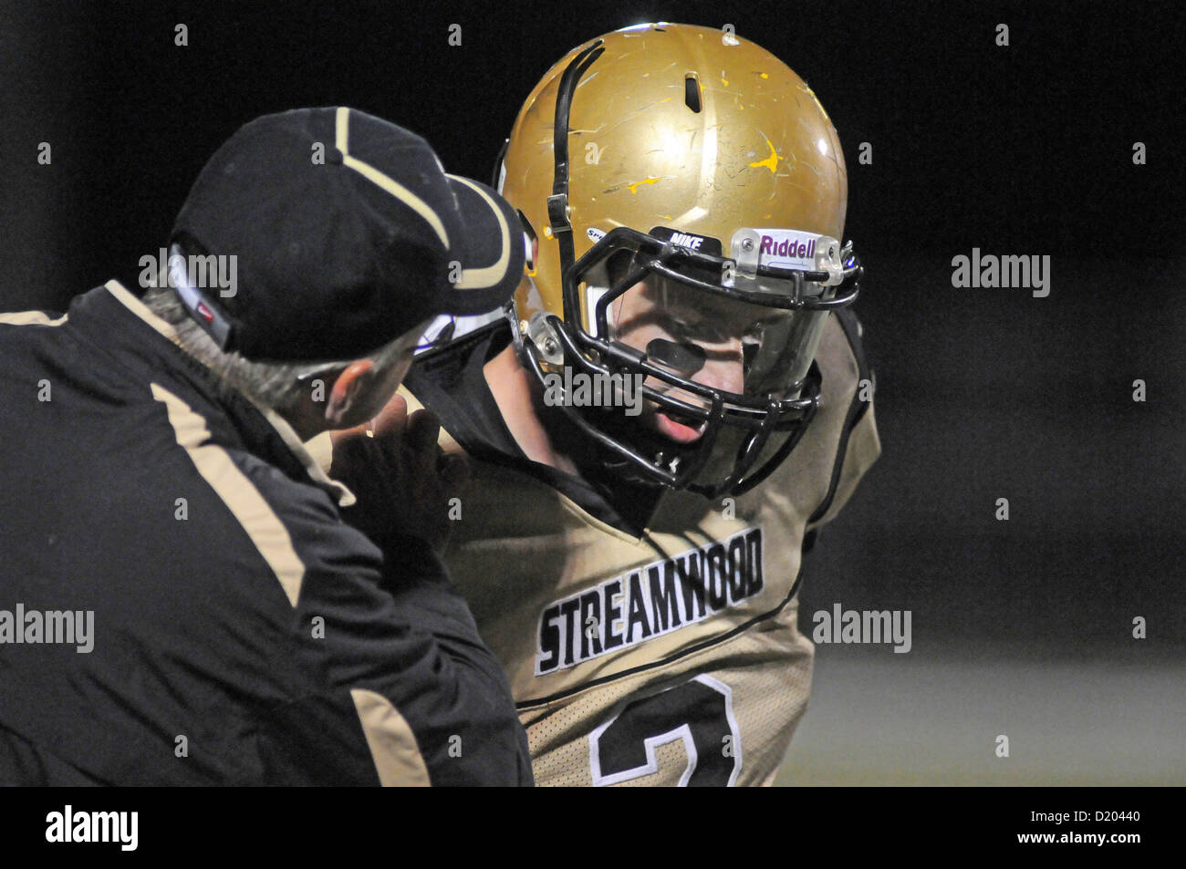 Allenatore di calcio fornisce le istruzioni di gioco al suo quarterback prima di un gioco. Stati Uniti d'America. Foto Stock