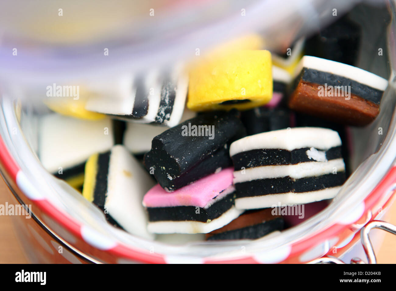 Liquirizia Allsorts in un contenitore con la plastica opaca coperchio aperto a metà strada Foto Stock
