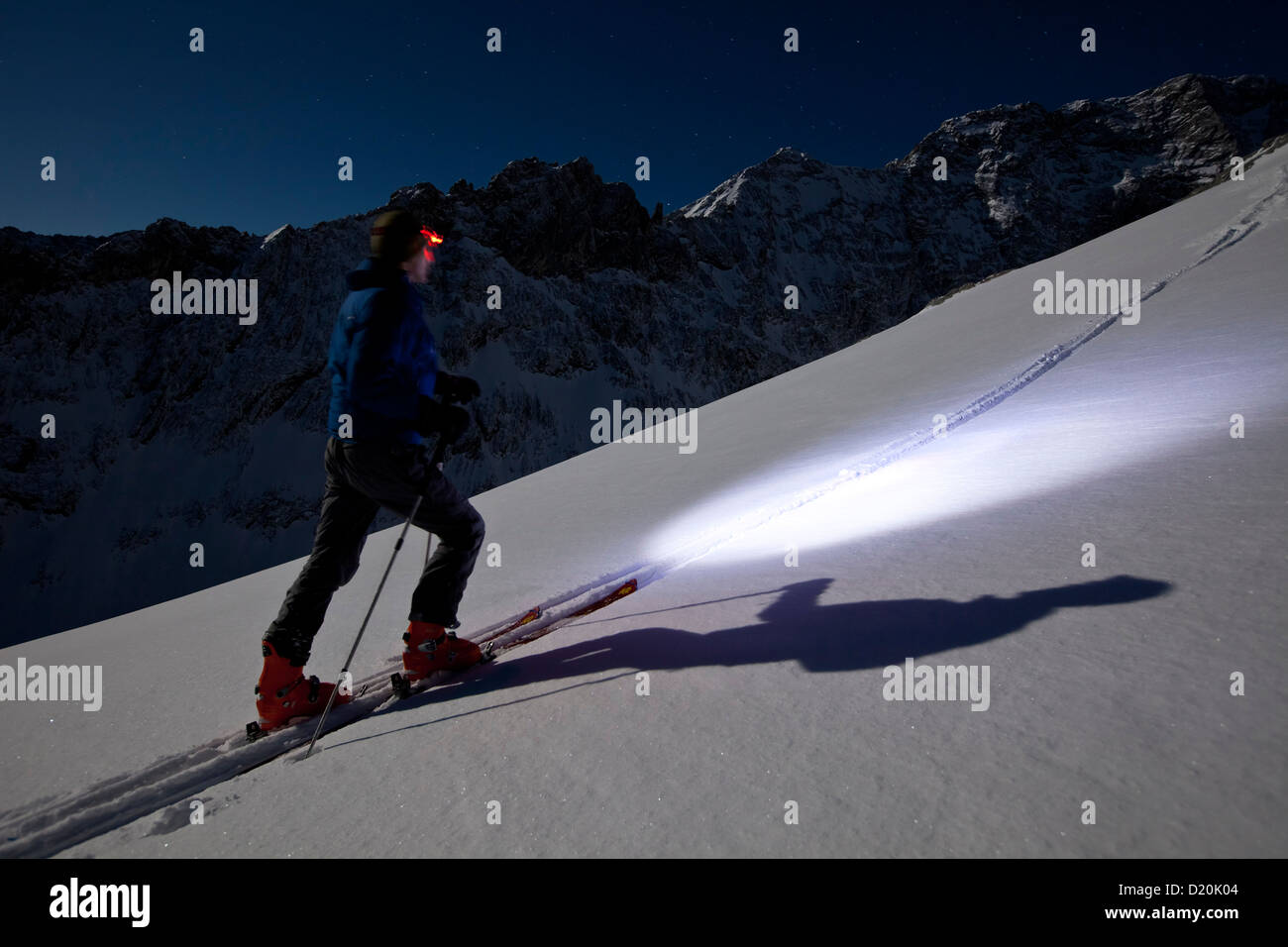 Persona backcountry sci al chiaro di luna con proiettore, Alpspitze, Wetterstein, Alpi, Baviera, Germania Foto Stock