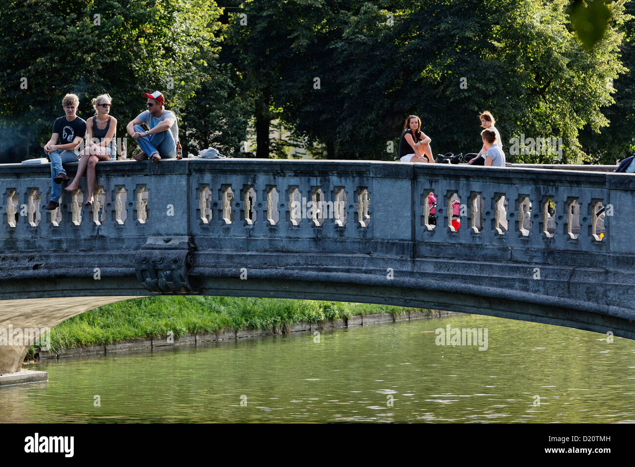 Persone su un ponte al di sopra del castello di Nymphenburg canal, Gern, Monaco di Baviera, Baviera, Baviera, Germania, Europa Foto Stock