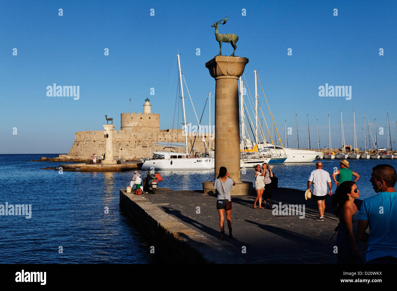 Colonne all'entrata del porto di Mandraki e Agios Nikolaos fortezza nella luce del sole, RODI, RODI, DODECANNESO ISL Foto Stock