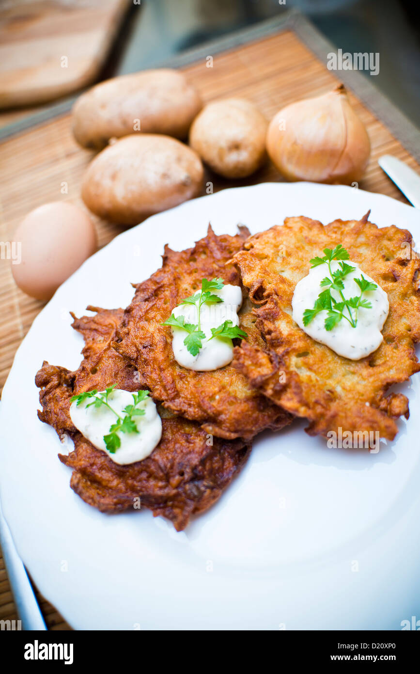 Frittelle di patate con panna acida e prezzemolo Foto Stock