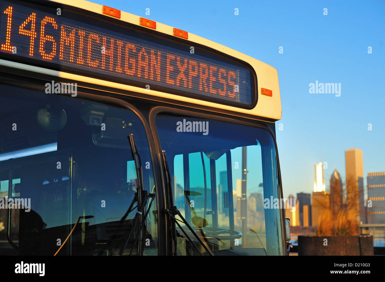 Stati Uniti Illinois Chicago Rising Sun si riflette sulla parte anteriore di un bus CTA Foto Stock