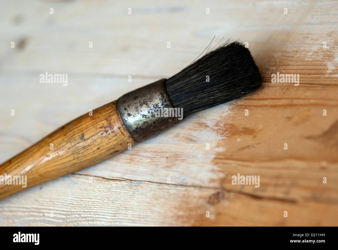 Un vecchio artisti spazzola di vernice contro un prt dipinta sullo sfondo di legno Foto Stock