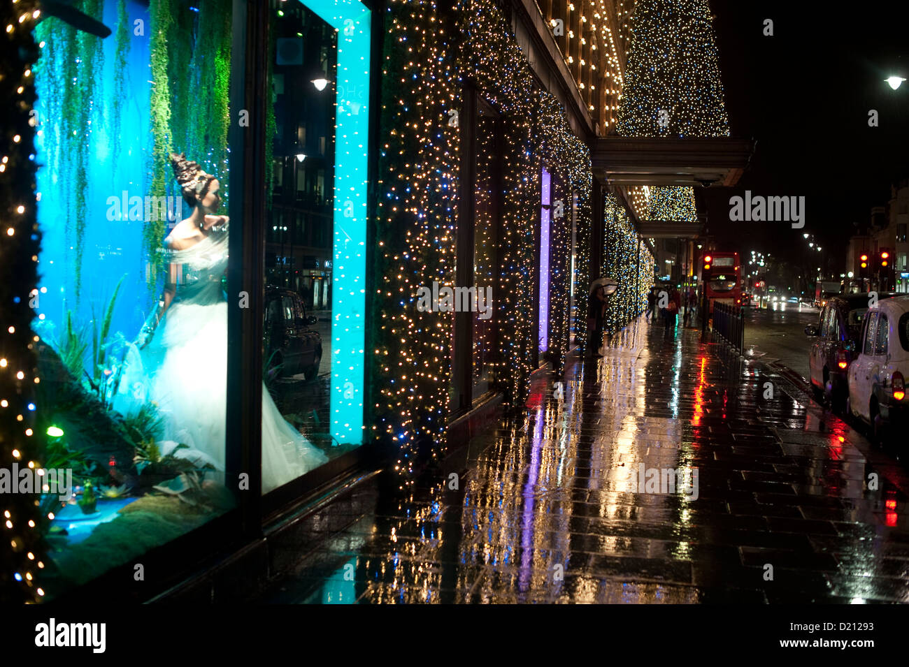 Una notte piovosa in Knightsbridge intorno Harrods illuminato con luci di Natale Foto Stock
