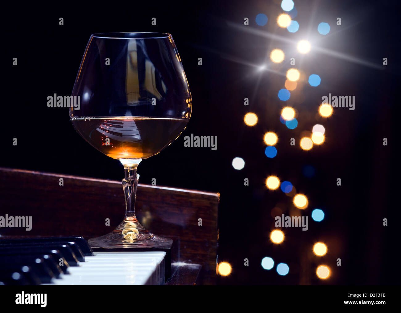 Snifter con brandy su un pianoforte Foto Stock