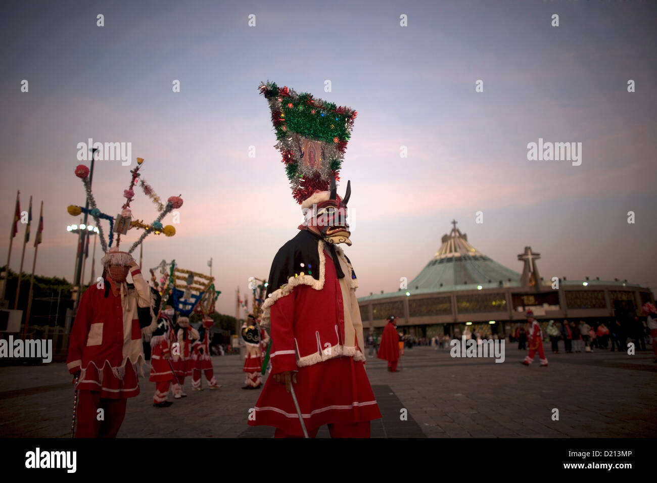 Un pellegrino vestito come un diavolo rosso esegue il baile de los Santiagos o Saint James's Dance al di fuori della Nostra Signora di Guadalupe Foto Stock