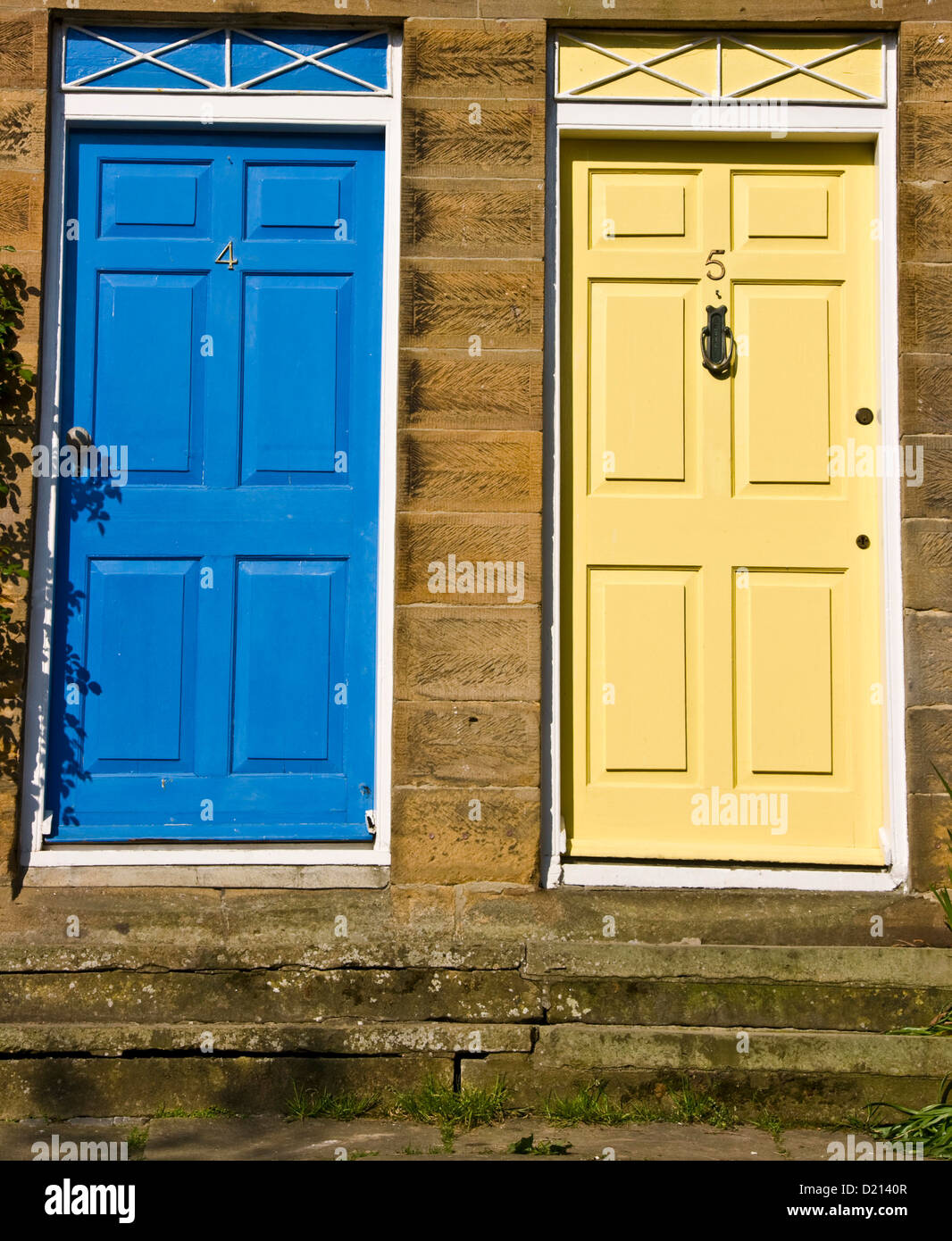 Coppia di porte di casa affiancati uno blu uno giallo Foto Stock