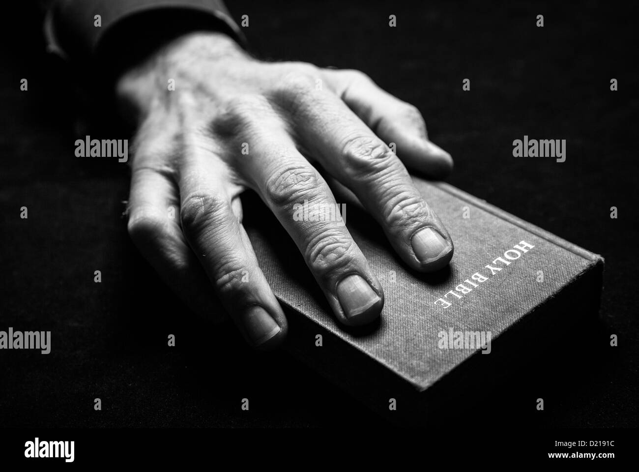 Una immagine in bianco e nero di un mans mano che tiene la Sacra Bibbia. Foto Stock