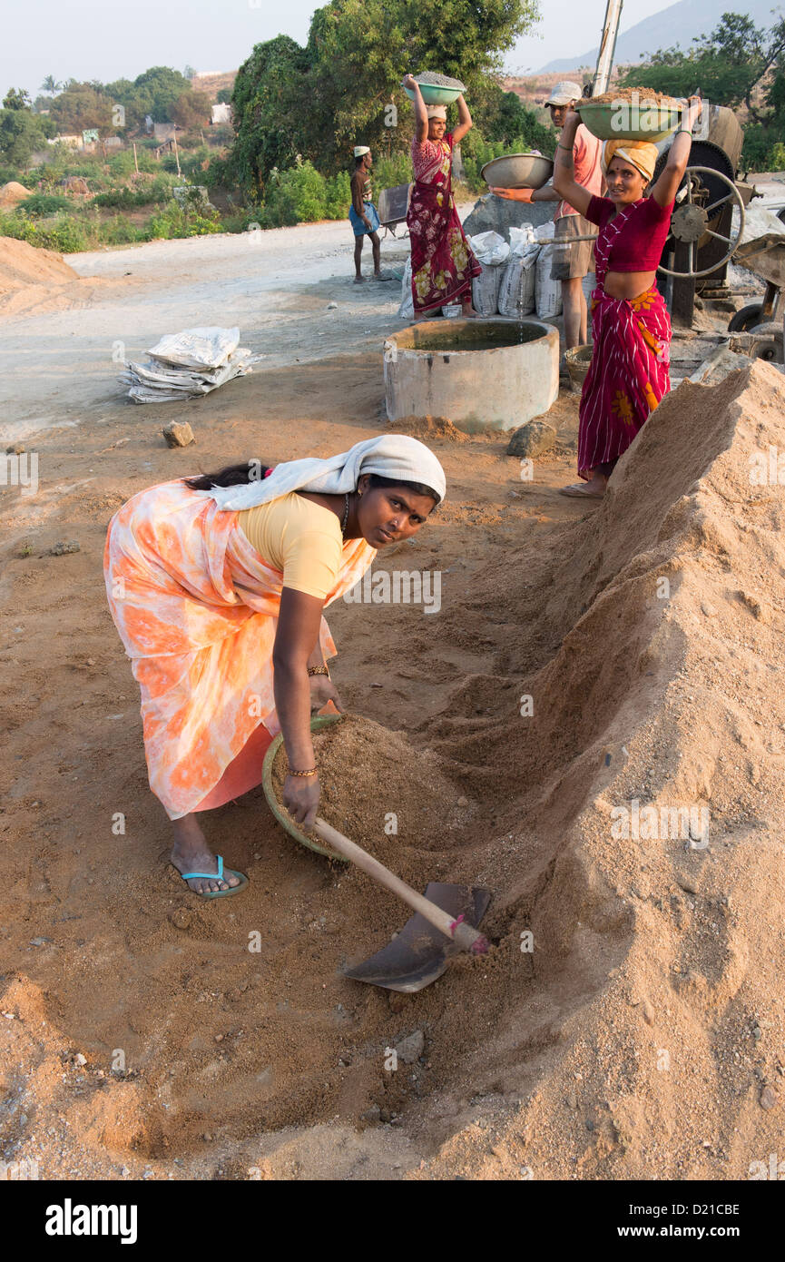 Popolo Indiano la miscelazione di sabbia e cemento per la produzione di blocchi in calcestruzzo. Andhra Pradesh, India Foto Stock