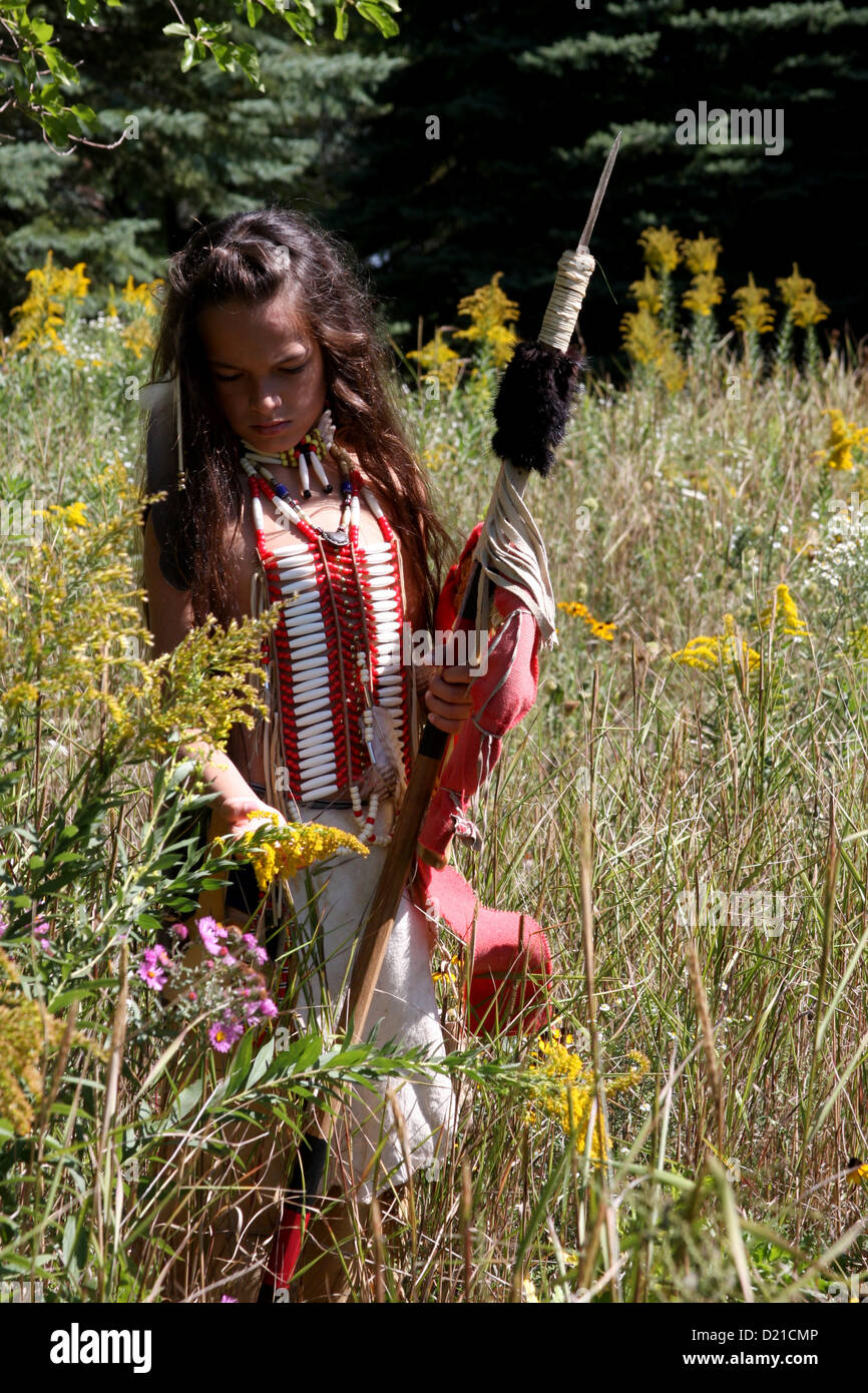 Un Native American Indian boy con la lancia e lo scudo a piedi attraverso la prateria di graminacee Foto Stock