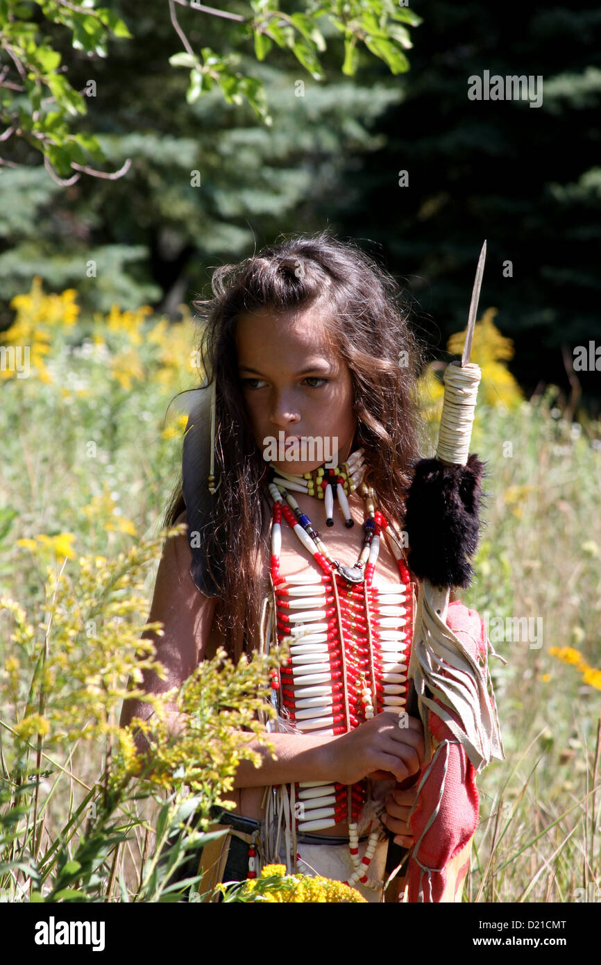 Un Native American Indian boy con la lancia e lo scudo a piedi attraverso la prateria di graminacee Foto Stock